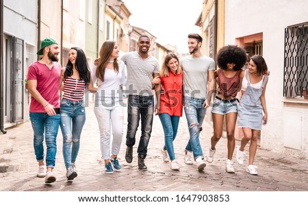 Multiracial millennial friends walking in city center - Happy guys and girls having fun around old town streets - University students on travel vacations - Warm desaturated filter Royalty-Free Stock Photo #1647903853