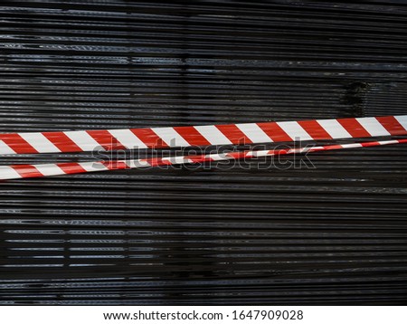 red and white barrier tape over black nylon background