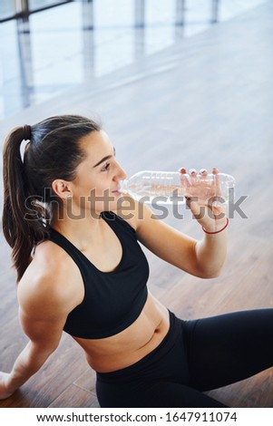 Young sporty woman in sportswear tired and have a break in the gym.