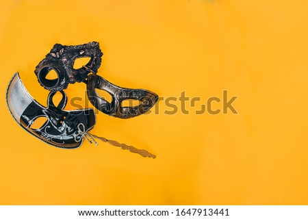 Carnival masks lies on a yellow background. Minimalism mood. Close-up, copy space