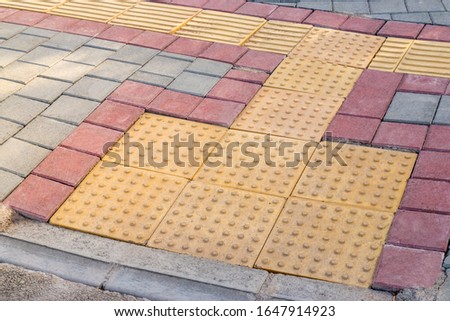 Ramp for wheelchair and other wheeled pedestrian transport made from tiles of various color. Accessibility concept.