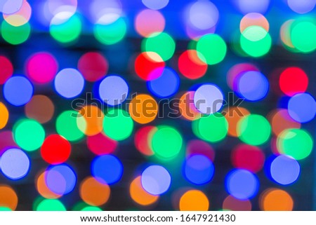 Beautiful bokeh in the form of medium-sized multicolored circles against a dark background