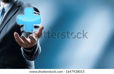 Businessman hand holding medical plus sign