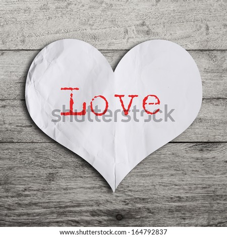 Love word on red heart shape with wooden wall 