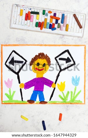 Photo of colorful drawing: Left and right arrow signs. Future and past concept. Smiling boy holding two signs.