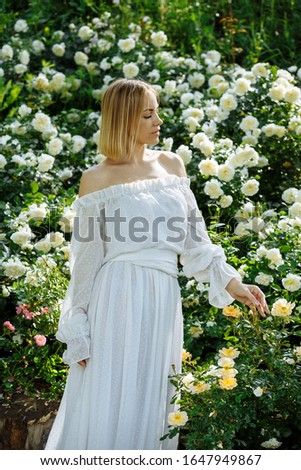girl in a white dress in the garden with white roses