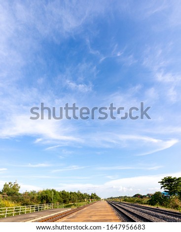 Blue sky with clouds, Sky background image, Platforms and railway tracks at bottom of picture.