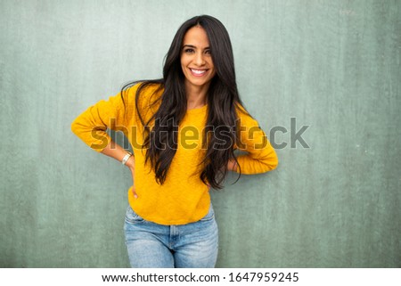 Portrait beautiful young brunette woman laughing by green background 