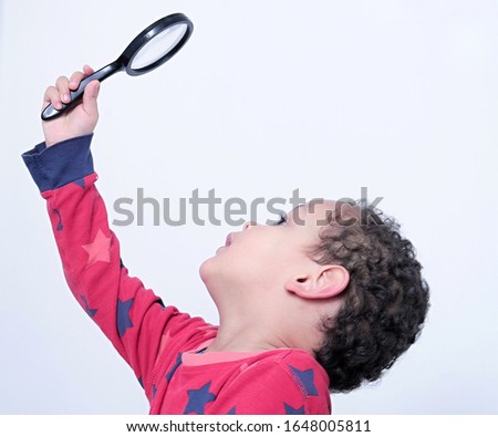 child with magnifying glass ready to explore on white background stock photo 