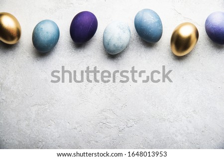 Natural dyed colorful Easter eggs on grey concrete background top view. Easter holiday banner, card, concept, design.