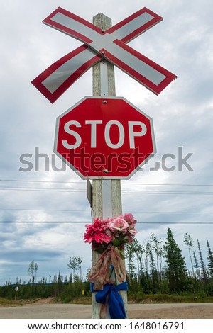 Railroad crossing stop sign with flowers
