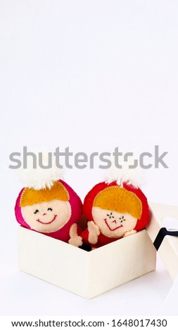 postcard with small handmade toys in gift box on white background with copy space.
