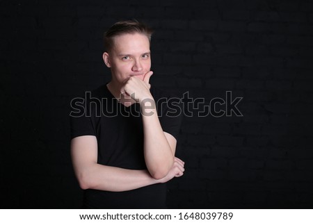 portrait emotional cool stylish young guy in a black t-shirt and shirt on a dark background