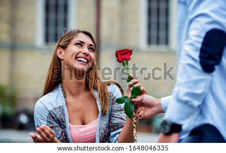 Dating. Young man surprised his girlfriend with a red rose. Love and relationships Royalty-Free Stock Photo #1648046335