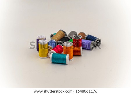 colored sewing and knitting threads on white and grey background