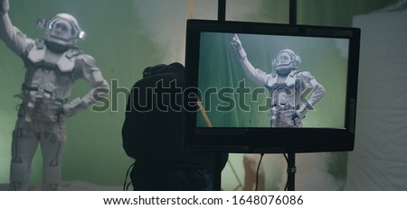 Medium shot of shooting a scene with an astronaut and the crew celebrating