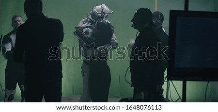 Medium shot of shooting a scene with an astronaut and the crew celebrating