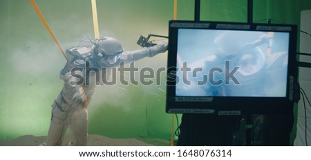 Medium shot of the shooting of a scene with an astronaut struggling against the wind