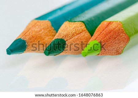 green pencil on white background close-up