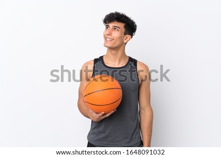 Basketball player man over isolated white background looking up while smiling