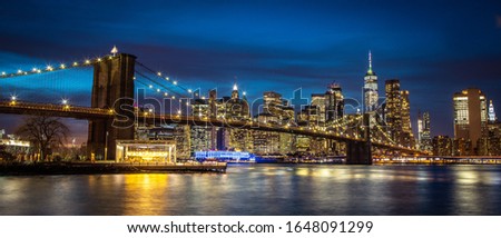 New York skyline during the blue hour with Brooklyn bridge in the background.