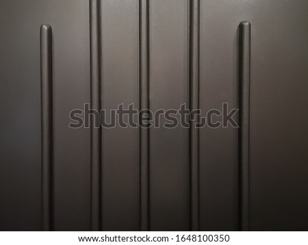 Ribbed metal surface resembling bar chart. Close-up photo of industrial facility fragment. Abstract background with parallel lines on the subject of modern industry, technology or architecture.