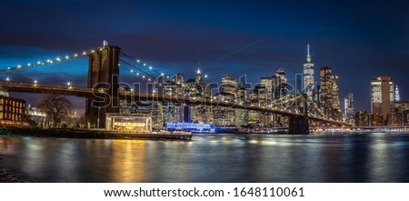 New York skyline during the blue hour with Brooklyn bridge and the One World Trade Center in the background.