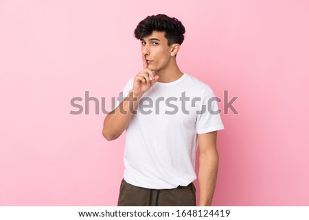 Young Argentinian man over isolated pink background doing silence gesture