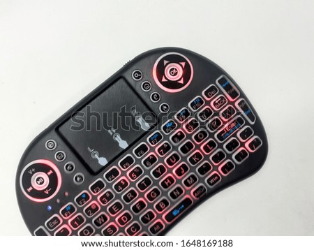 Modern Artistic Black TV Remote with QWERTY Keypad and Game Tools in White Isolated Background