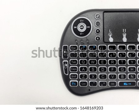Modern Artistic Black TV Remote with QWERTY Keypad and Game Tools in White Isolated Background