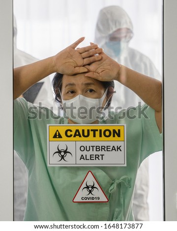 coronavirus covid 19 infected patient in coronavirus covid 19 quarantine room with quarantine and outbreak alert sign at hospital with blurred disease control experts, coronavirus outbreak control Royalty-Free Stock Photo #1648173877