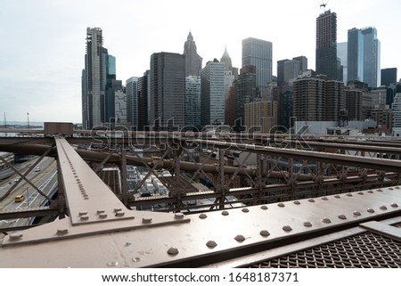 New York's Manhattan City Skyline From The Iconic Brooklyn Bridge.