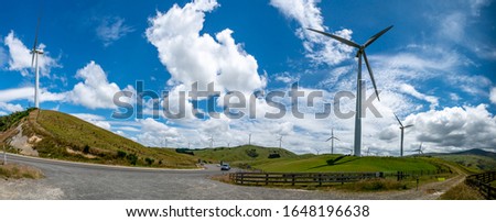 Massive wind turbine towers generating electricity in beautiful rural agricultural  countryside