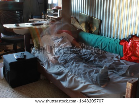 Man leaving his body from a bed during an outer-body experience Royalty-Free Stock Photo #1648205707