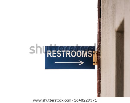 Arrow sign outside public restrooms at a tourist destination (selective focus)
