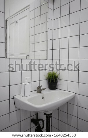 Bathroom in Cafe, toilet room interior close-up. The walls decorative with white glossy ceramic tiles