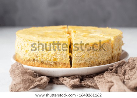 Pumpkin cheesecake with caramel sauce, light grey stone background. Selective focus.