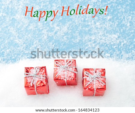 Christmas card Happy Holidays with red gifts on snow