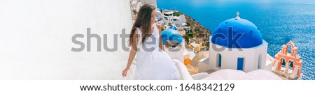 Travel Greece vacation panoramic honeymoon luxury cruise Europe mediterranean destination woman tourist of Santorini island. Elegant happy lady walking in white dress at famous stairs panorama.