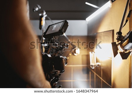 Video production backstage. Behind the scenes of creating video content, a professional team of cameramen with a director filming commercial ads. Video content creation, video creation industry. Low