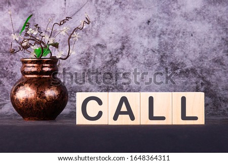 CALL written in wooden cubes on a grey background
