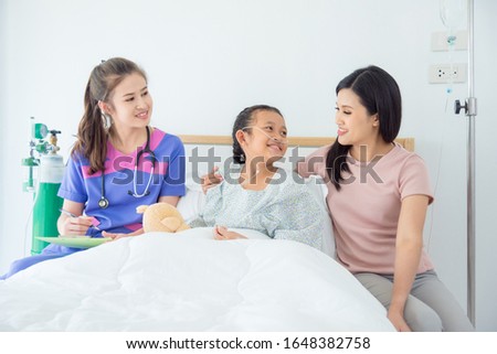 Young asian girl patient and her mother smiling while doctor visiting and talking with them at hospital ward.