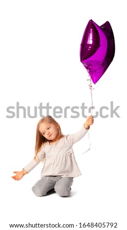 Cute little blonde girl with purple star shaped baloon isolated on white background