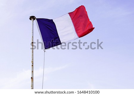French flag of France waving over a blue sky blue white red color