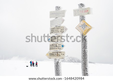 Mountain signpost sign arrow way point navigation in winter