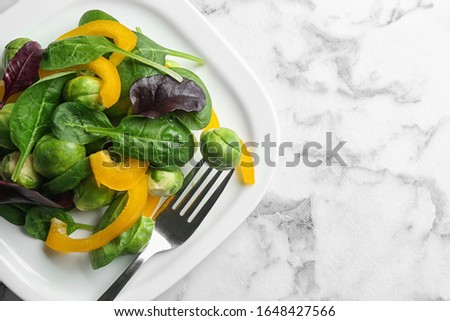 Tasty salad with Brussels sprouts on white marble table, top view. Space for text