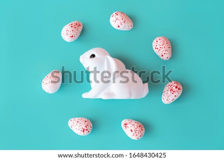 White toy neon rabbit with eggs candy on Neo mint background . Festive easter layout. Minimal Creative Idea Concept. Family holiday. Baby kids fun