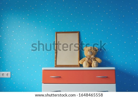 Wooden photo frame and toy in blue star kids room. 