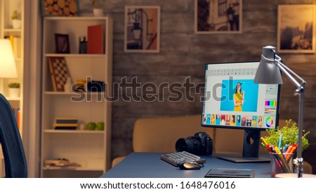 Photographers room late at night with professional editing software on computer screen