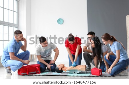Instructor demonstrating CPR on mannequin at first aid training course Royalty-Free Stock Photo #1648477156